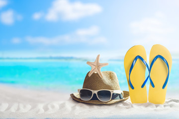 Fototapeta na wymiar Summer Holiday, hat and flip flop on white sand