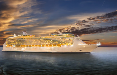 Luxury cruise ship sailing to port on sunset. 