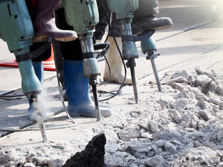 A Worker man drilling in concrete on a construction site