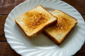 Plate with toasted bread isolated on white background, top view