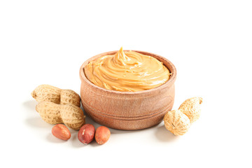 Creamy peanut butter in glass bowl and peanut isolated on white background. A traditional product of American cuisine
