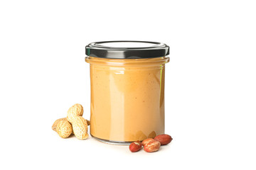 Creamy peanut butter in glass jar and peanut isolated on white background. A traditional product of American cuisine