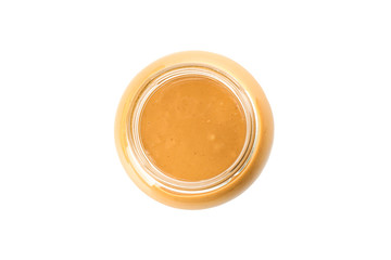 Creamy peanut butter in glass jar isolated on white background, top view. A traditional product of American cuisine