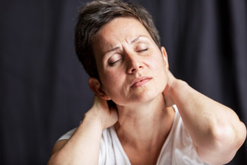 Emotional portrait of an adult woman with short hair and closed eyes. Close-up. Black background.