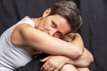 Emotional portrait of an adult woman with short hair. Close-up. Black background.