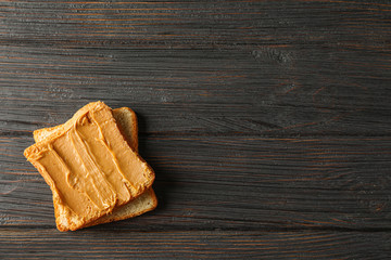 Peanut butter sandwich on wooden background, space for text and top view