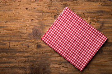 Obraz premium Empty wooden deck table and red checked tablecloth over mint wallpaper background