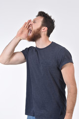 man putting a hand in mouth and is screaming on white background