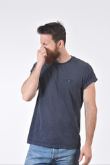 Fototapeta premium man who covers his nose with his fingers because it makes an smell bad