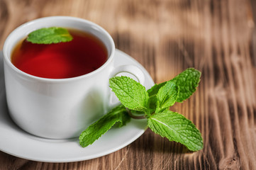 Cup with tea and mint on the old table
