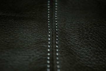 White stitched seam on black leather - obrazy, fototapety, plakaty