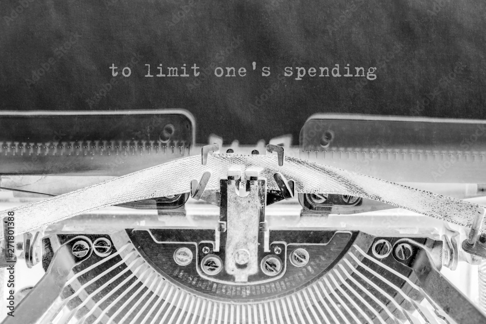 Fototapete to limit one's expense is printed on a sheet of paper on a vintage typewriter.