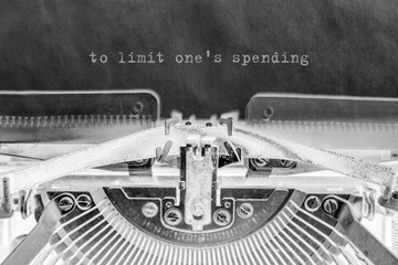 to limit one's expense is printed on a sheet of paper on a vintage typewriter.