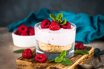 No baked cheesecake with raspberry in glass jar.