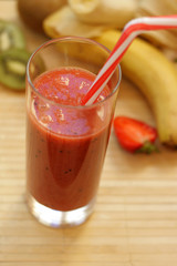 Fresh strawberry-banana smoothie with the addition of kiwi in a glass