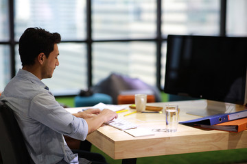 Portrait of young man sitting at his desk in the office