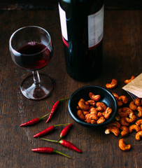 Spicy cashew nuts flavoured with balsamic vinegar and chilli on rustic wooden table
