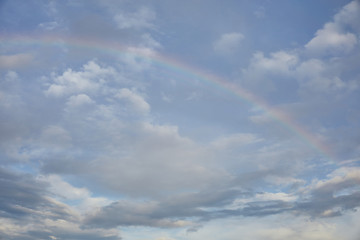 Fototapeta na wymiar rainbow on blue sky background and white clouds