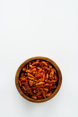 Fototapeta na wymiar Dried bird's eye chili peppers in a wooden bowl. White background, high resolution