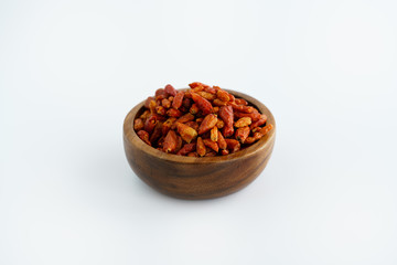 Dried bird's eye chili peppers in a wooden bowl. White background, high resolution