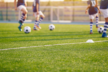 Fototapeta premium Blurred Soccer Field at School. Young Soccer Players Training on Pitch. Soccer Stadium Grass Background