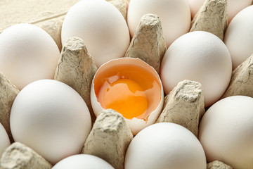 White chicken eggs in carton box as background, closeup
