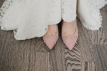 Closeup of a caucasian bride put on her pink shoes.
