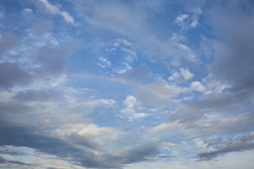 Fototapeta na wymiar view of rainbow on blue sky background and blue clouds