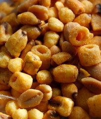 Golden mixed nuts, snacks, chips for beer close-up with selective focus.