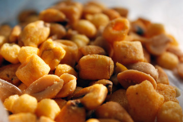 Golden mixed nuts, snacks, chips for beer close-up with selective focus.