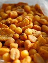 Golden mixed nuts, snacks, chips for beer close-up with selective focus.