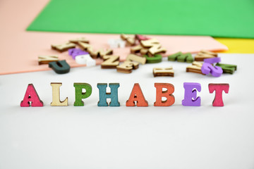 the word alphabet is composed of multi-colored wooden letters