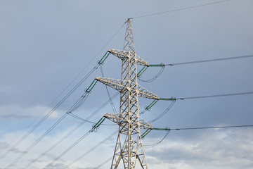 view of electric pole with long wires on grey sky background