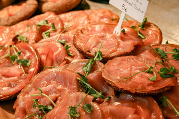 Traditional delicious salted smoked sliced salmon with black bread, old city market hall in Helsinki, Finland 