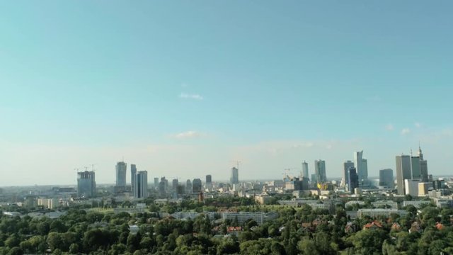 Aerial View of Warsaw City - Capital of Poland - with Skyscrapers, Palace of Culture and Science and Green Park on Summer Day. 4K Quadcopter Pan Shot