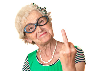 An older woman with an angry facial expression shows fuck you. Isolated The concept of discontent and protest of old men