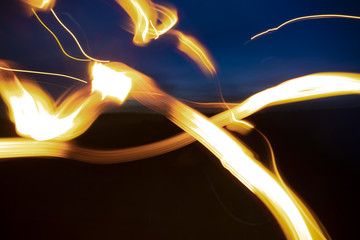 Abstract background. Glowing fiery curved stripes on black and blue