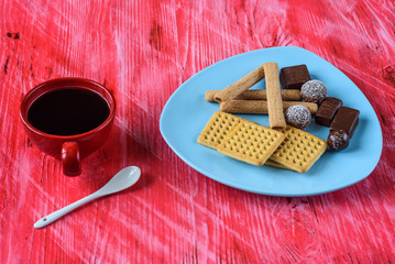 Homemade pastries and chocolates on a ceramic plate on a wooden background.