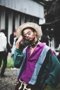 man in purple button-up shirt and brown hat