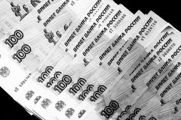 Russian banknotes of a hundred rubles on a dark background close up. Black and white