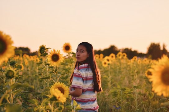 woman standing in front of sunflower field