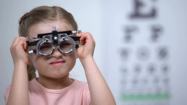 Doctor wearing optical trial frame on child to diagnose myopia, blurred vision