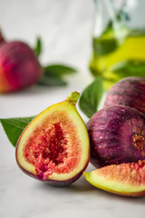 Half and whole figs on gray cement or stone background.