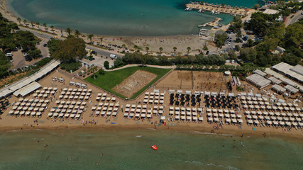 Aerial drone bird's eye panoramic photo of famous celebrity sandy beach of Astir or Asteras in south Athens riviera with turquoise clear waters, Vouliagmeni, Greece