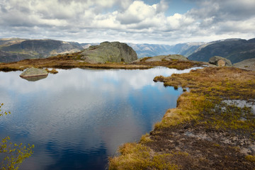Naklejka na ściany i meble Nature, the landscape of Norway, a small lake on a high rock plateau above lysefjord