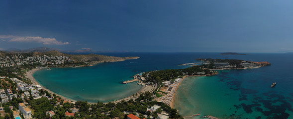 Aerial drone bird's eye panoramic photo of famous celebrity sandy beach of Astir or Asteras in south Athens riviera with turquoise clear waters, Vouliagmeni, Greece