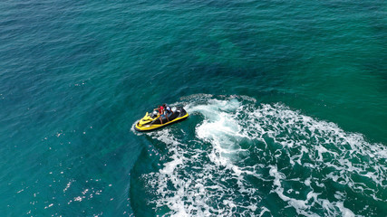 Aerial drone top view photo of jet ski cruising in high speed in emerald exotic tropical bay