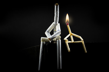 image of a character made of cigarette, alone and sad with black background. Concept of addiction...