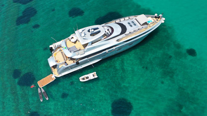 Fototapeta na wymiar Aerial drone top view photo of large yacht - boat docked in tropical exotic paradise bay with emerald open ocean