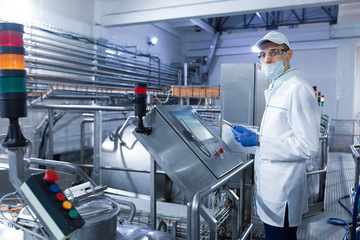 man in a white robe and a cap make a configure the digital screen